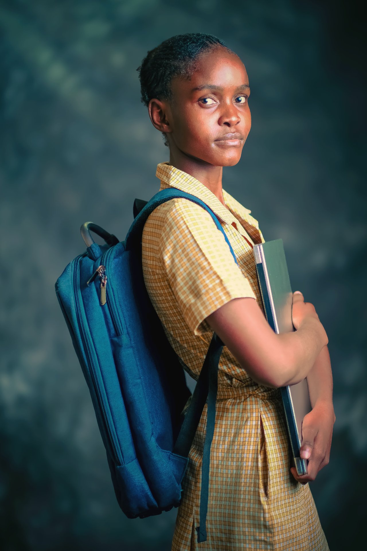 A young student with a backpack and books